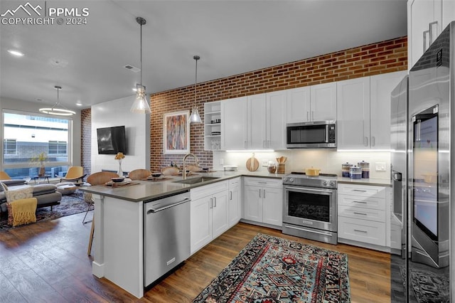 kitchen featuring white cabinetry, open floor plan, appliances with stainless steel finishes, and a sink