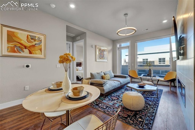 living room with recessed lighting, visible vents, wood finished floors, and baseboards