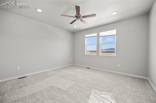 carpeted empty room featuring ceiling fan