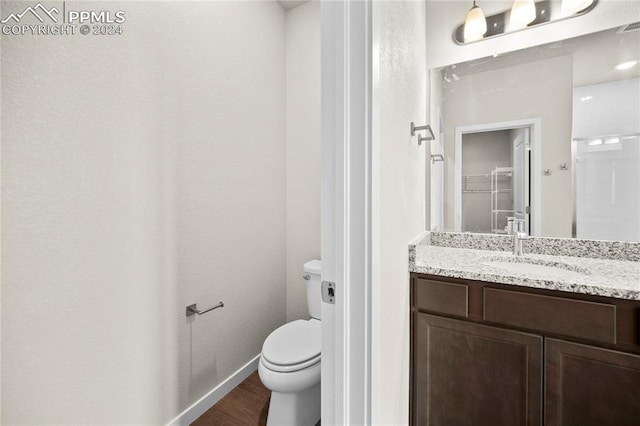 bathroom with vanity, toilet, and hardwood / wood-style flooring