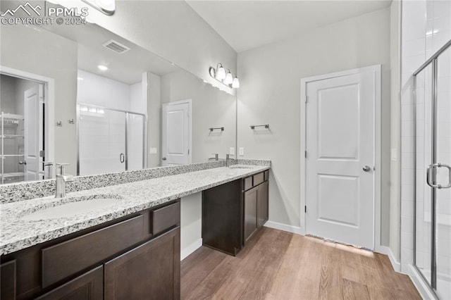 bathroom featuring vanity, hardwood / wood-style floors, and a shower with door