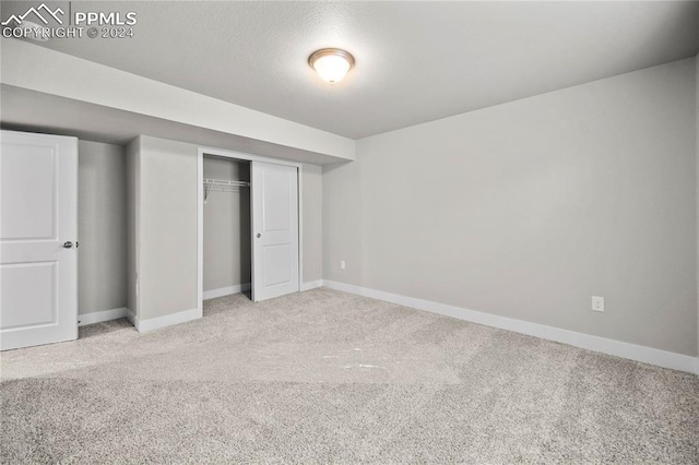 unfurnished bedroom with light carpet and a closet