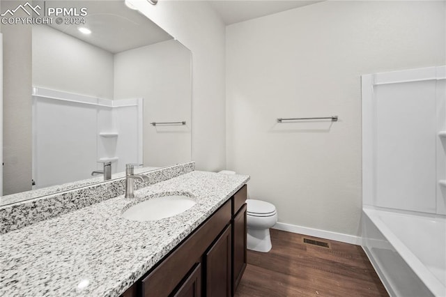 bathroom featuring wood-type flooring, vanity, and toilet