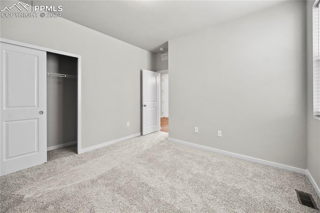 unfurnished bedroom featuring a closet and carpet flooring