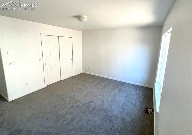 unfurnished bedroom featuring dark colored carpet