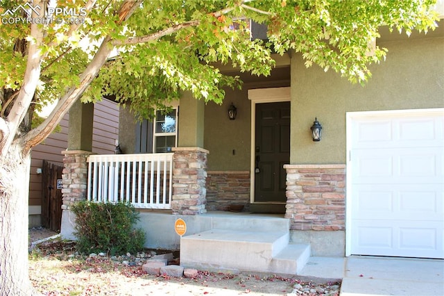 entrance to property featuring a garage and a porch