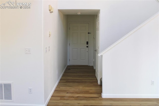 corridor with hardwood / wood-style flooring