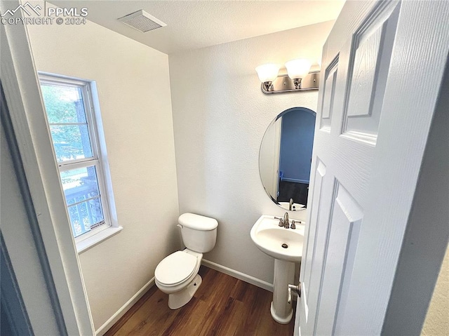 bathroom featuring hardwood / wood-style floors, a textured ceiling, and toilet