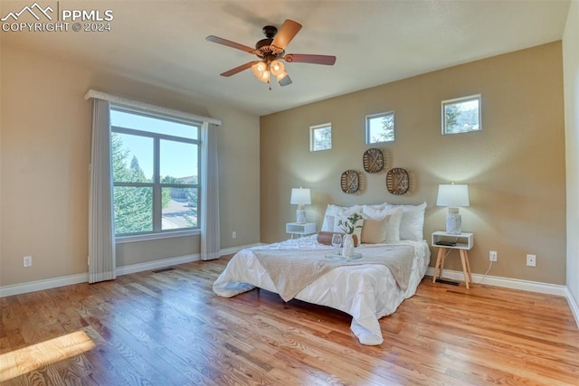 bedroom with multiple windows, light wood-type flooring, and ceiling fan