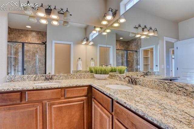 bathroom featuring a shower with door and vanity