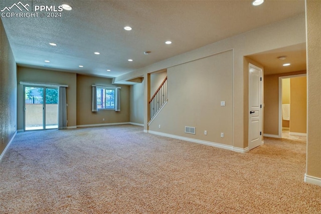 carpeted empty room with a textured ceiling