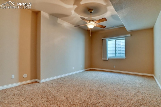 empty room featuring a textured ceiling, carpet floors, and ceiling fan