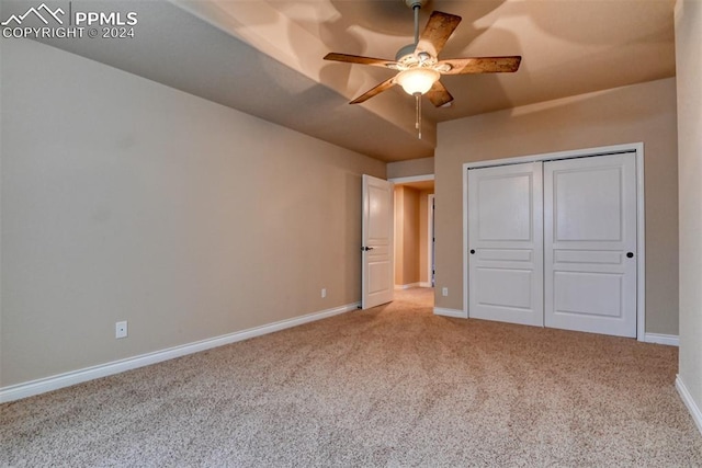 unfurnished bedroom with a closet, carpet flooring, and ceiling fan