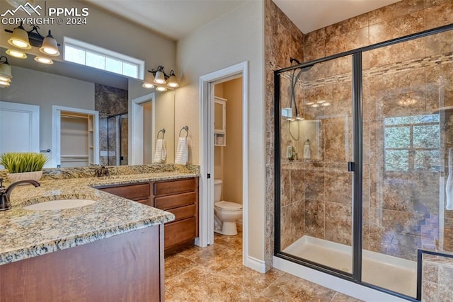 bathroom with toilet, an enclosed shower, and vanity