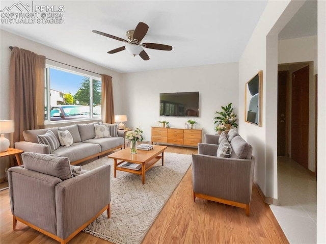 living room featuring light wood-type flooring and ceiling fan