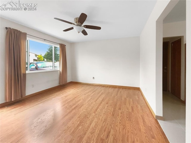 unfurnished room featuring light wood-type flooring and ceiling fan