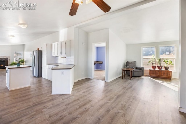 kitchen with a ceiling fan, dark countertops, white cabinets, freestanding refrigerator, and open floor plan