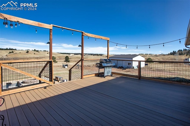 wooden terrace with a rural view and area for grilling