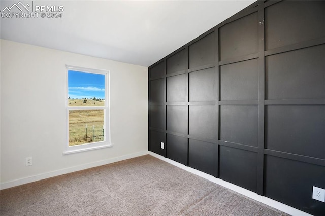 unfurnished room featuring baseboards and carpet