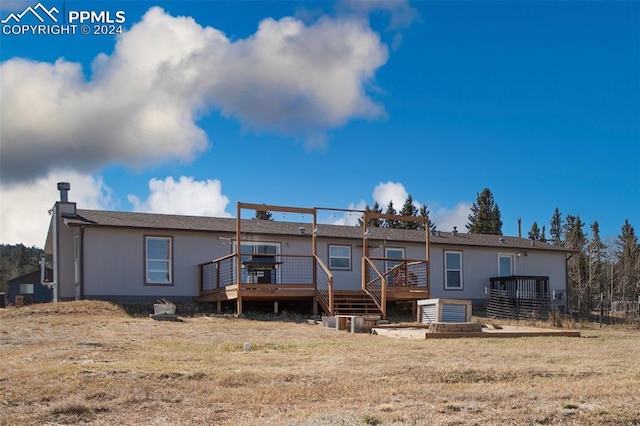 back of house featuring a wooden deck and a yard
