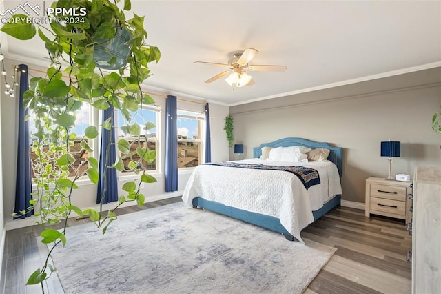 bedroom featuring ornamental molding, ceiling fan, and dark hardwood / wood-style flooring