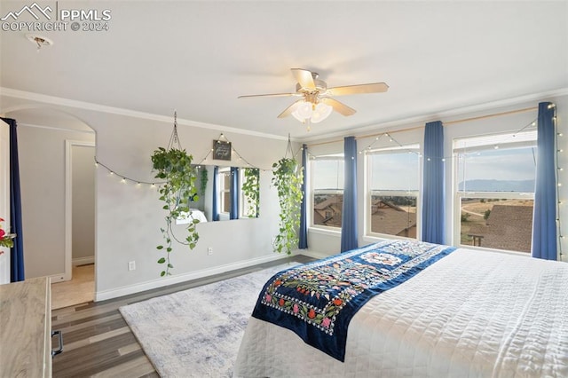 bedroom with ceiling fan, crown molding, and dark hardwood / wood-style flooring