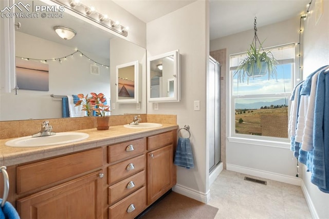 bathroom with tile patterned flooring, a shower with door, and vanity