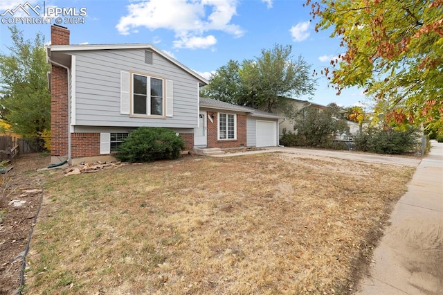 tri-level home with a front yard and a garage