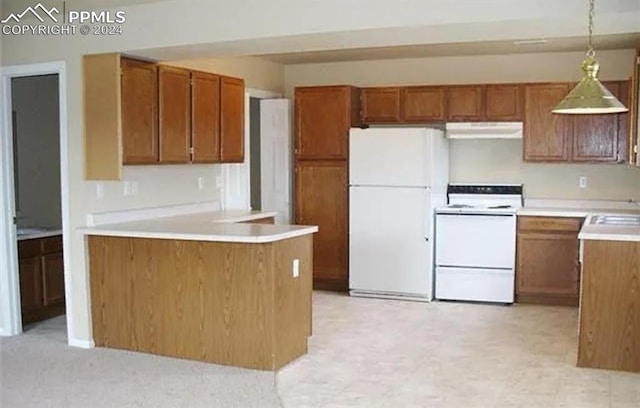 kitchen featuring decorative light fixtures, sink, and white appliances