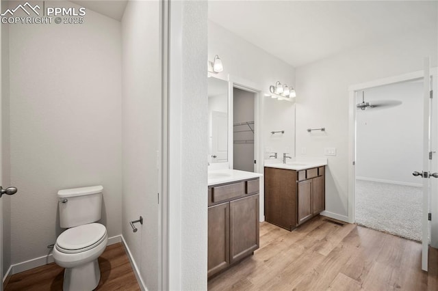 bathroom with toilet, baseboards, a sink, and wood finished floors