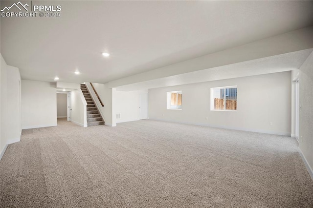 basement featuring light carpet, stairs, baseboards, and recessed lighting