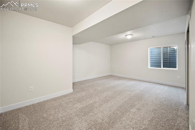 carpeted spare room featuring baseboards