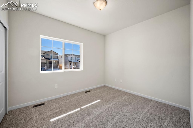 empty room featuring carpet floors, visible vents, and baseboards