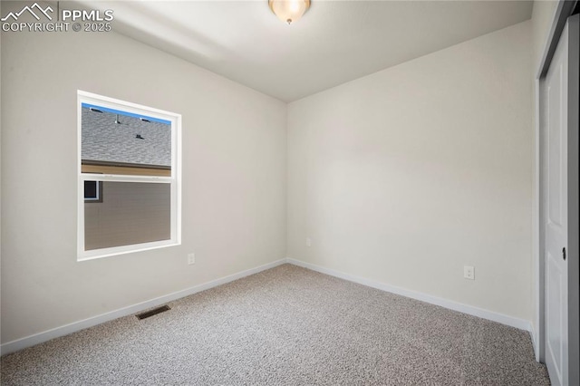 carpeted spare room featuring visible vents and baseboards