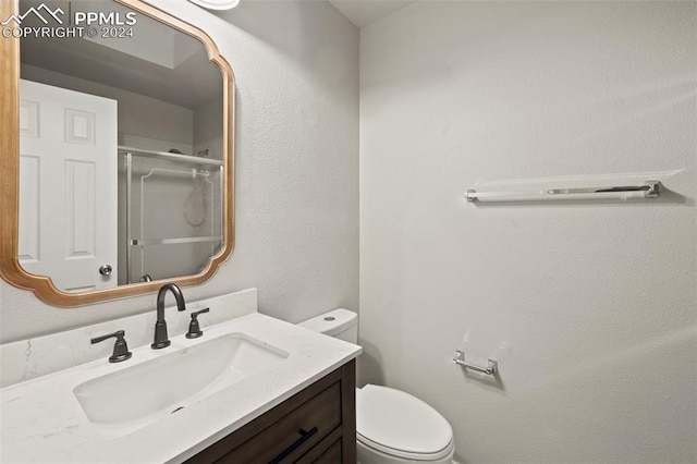 bathroom with toilet, walk in shower, and vanity