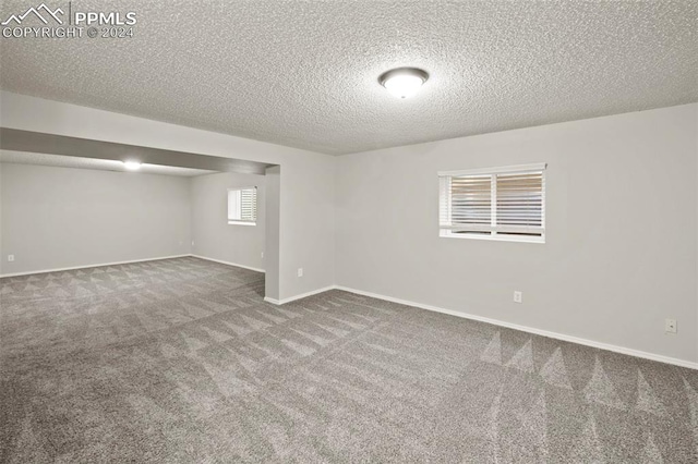 basement featuring carpet floors and a textured ceiling