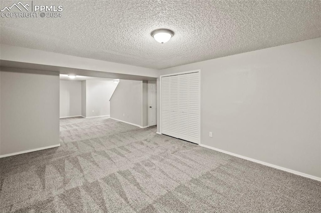 basement with a textured ceiling and carpet flooring