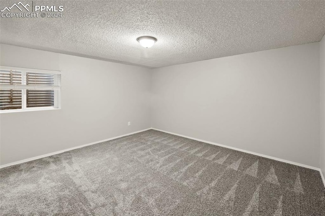 carpeted spare room featuring a textured ceiling