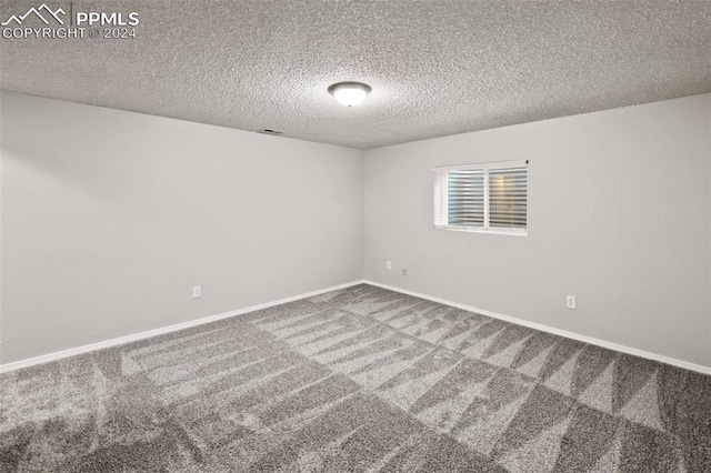 spare room featuring a textured ceiling and carpet floors