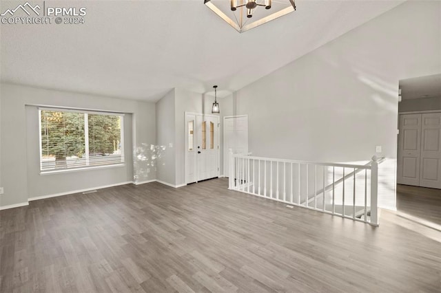 unfurnished living room featuring high vaulted ceiling and hardwood / wood-style flooring