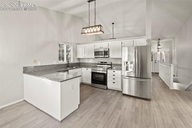 kitchen featuring kitchen peninsula, white cabinets, appliances with stainless steel finishes, light hardwood / wood-style flooring, and pendant lighting