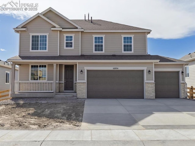craftsman-style house featuring concrete driveway, stone siding, a garage, and covered porch