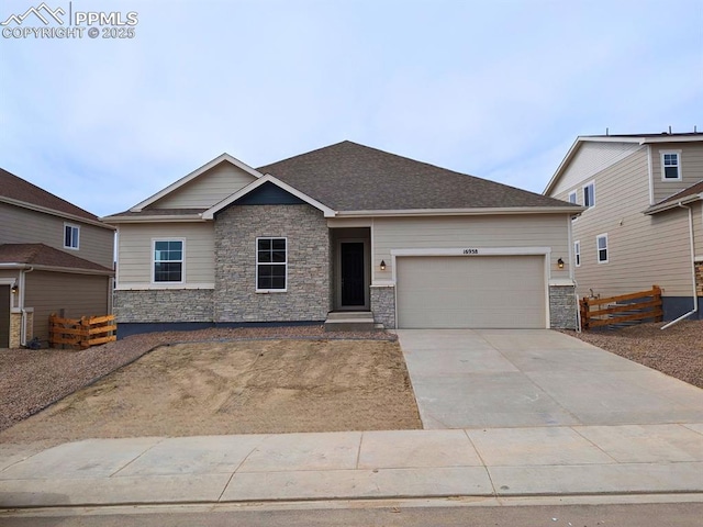 craftsman-style house with driveway, fence, stone siding, and a garage
