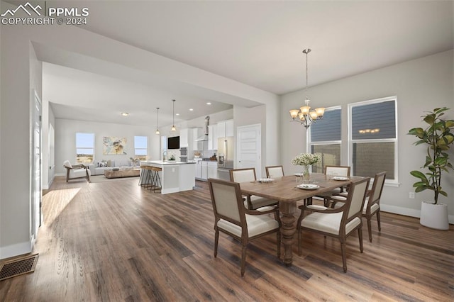 dining area featuring hardwood / wood-style flooring and an inviting chandelier