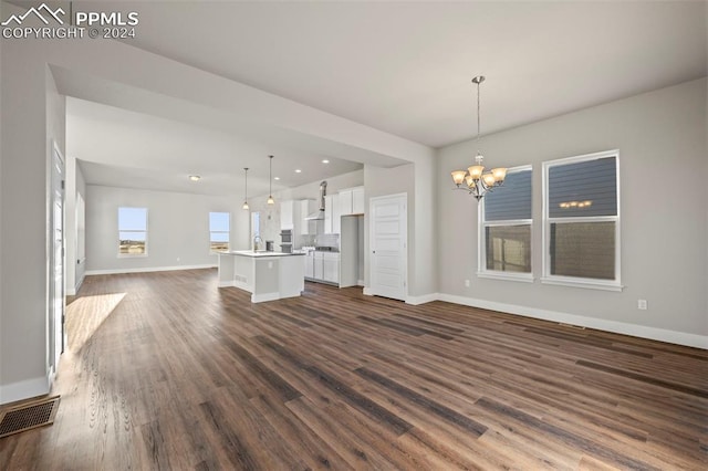 unfurnished living room with dark hardwood / wood-style flooring and a notable chandelier