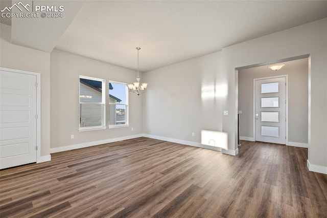 unfurnished dining area featuring dark hardwood / wood-style flooring and a chandelier