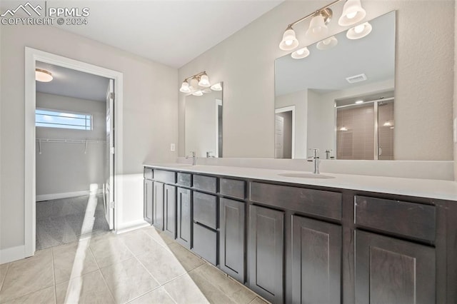 bathroom featuring tile patterned flooring, vanity, and a shower with door