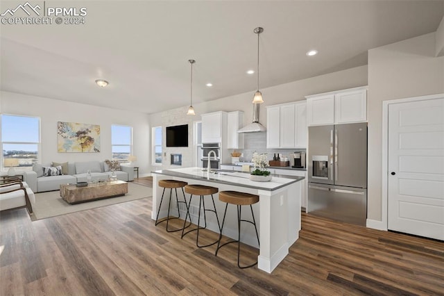 kitchen featuring a center island with sink, dark hardwood / wood-style floors, white cabinets, and stainless steel refrigerator with ice dispenser