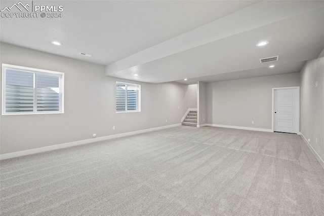 basement featuring light carpet