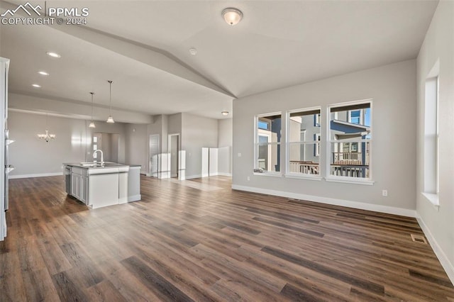 unfurnished living room featuring vaulted ceiling, sink, a chandelier, and dark hardwood / wood-style floors